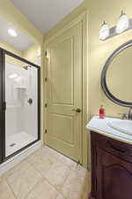 Bathroom featuring vanity, a stall shower, and light tile patterned floors