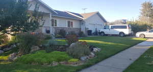 View of home's exterior with a lawn, an attached garage, and brick siding
