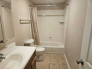 Full bath with vanity, shower / tub combo with curtain, and light tile patterned flooring