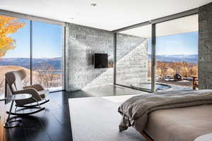 Bedroom featuring a mountain view and expansive windows