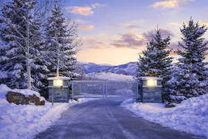 Snow covered gate with a mountain view