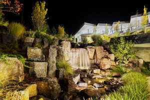 Yard at night featuring a small pond