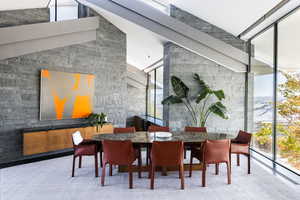 Carpeted dining room featuring a wall of windows, healthy amount of natural light, and lofted ceiling