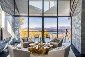 Living area with floor to ceiling windows and a mountain view