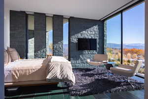 Bedroom with a wall of windows, multiple windows, and a mountain view