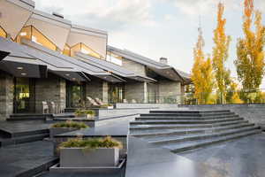 View of exterior entry featuring stone siding and a patio area