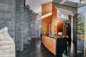 Full bath featuring a towering ceiling, vanity, and walk in shower