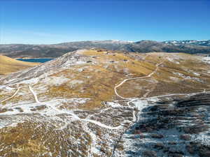 Snowy aerial view featuring a water and mountain view