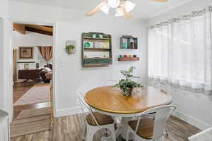 Dining area featuring wood finished floors, a ceiling fan, and vaulted ceiling