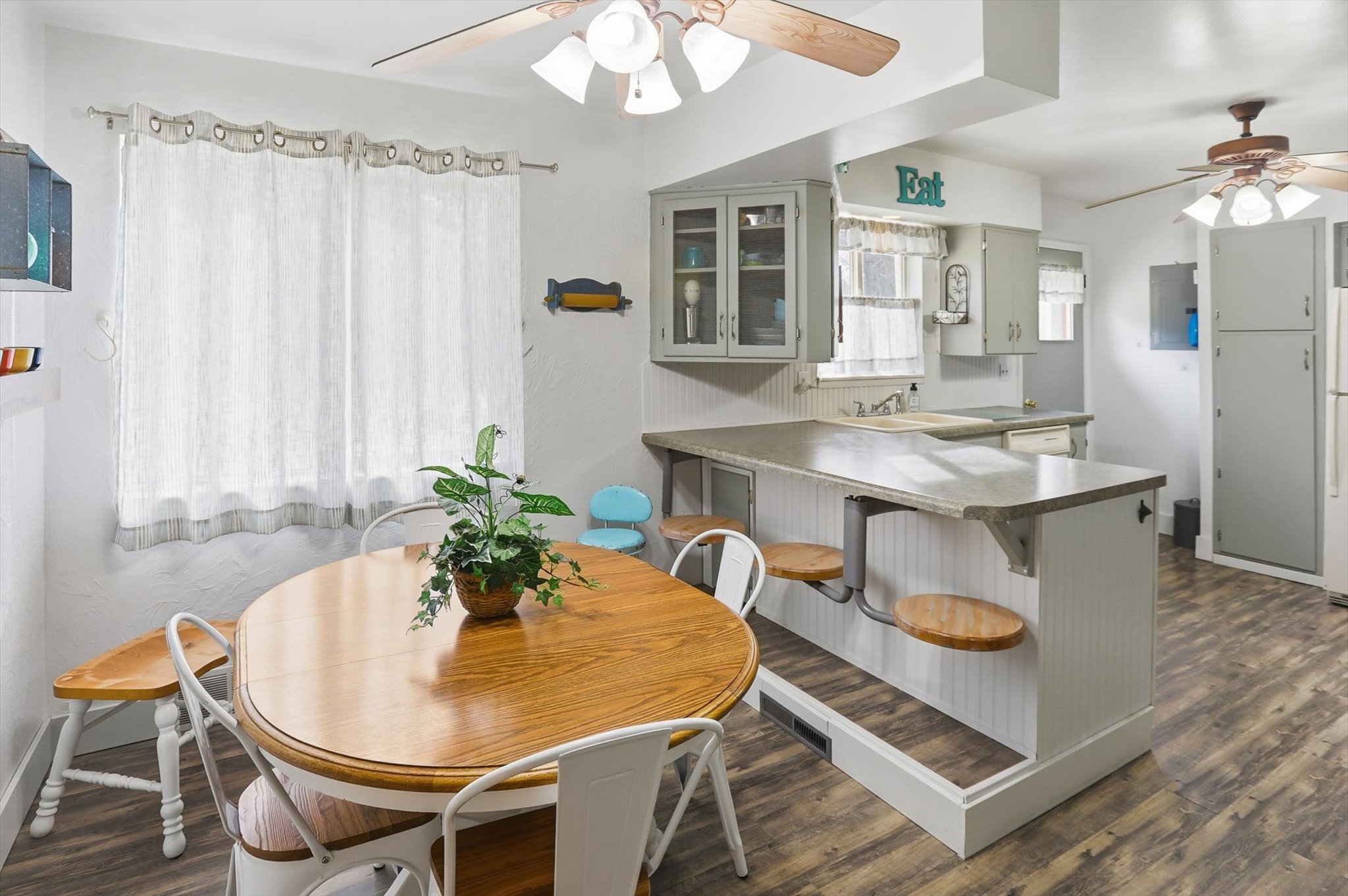 Dining space featuring a ceiling fan and dark wood-type flooring