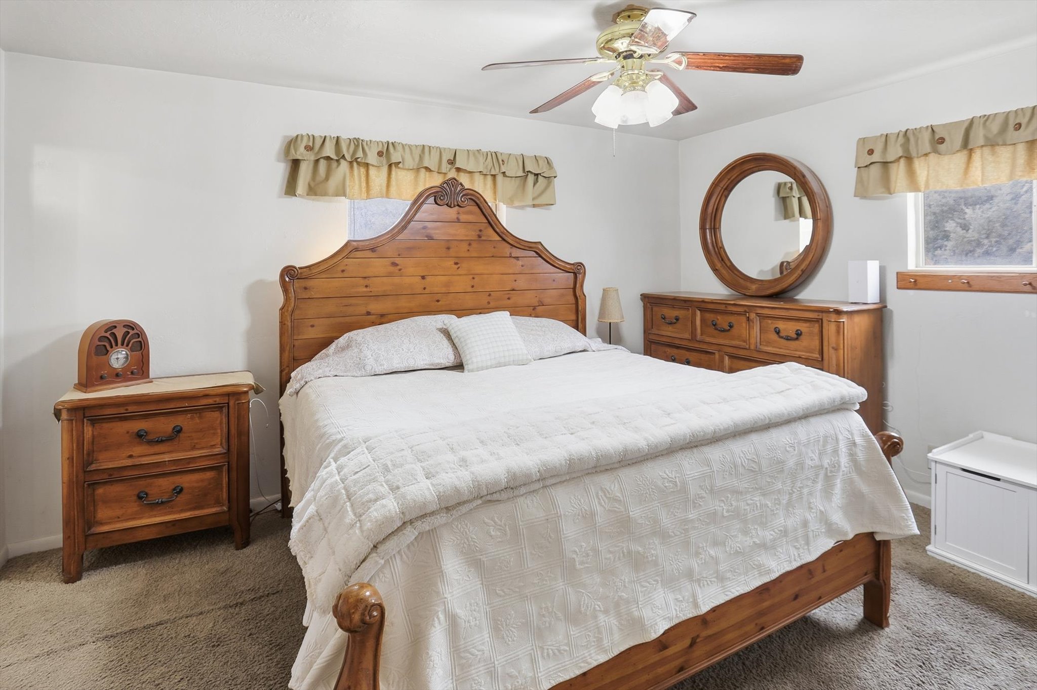 Carpeted bedroom with a ceiling fan and baseboards