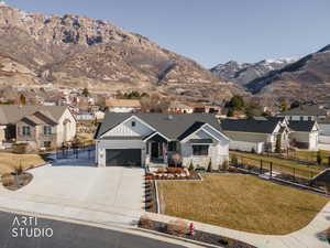 Modern farmhouse featuring a residential view, stone siding, driveway, a mountain view, and a garage