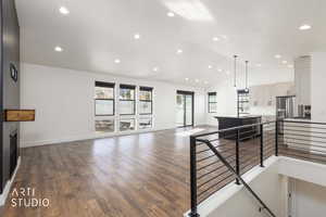 Living room featuring a fireplace, dark wood-style flooring, recessed lighting, and high vaulted ceiling