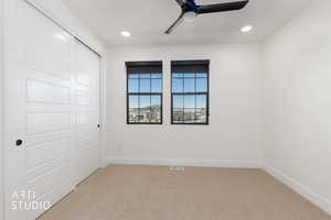 Unfurnished bedroom featuring light carpet, a closet, a ceiling fan, and recessed lighting