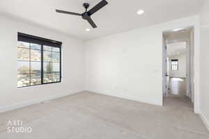 Empty room with light carpet, a ceiling fan, and recessed lighting