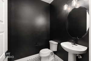 Half bath featuring toilet and tile patterned flooring
