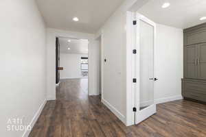Corridor featuring dark wood-type flooring and recessed lighting