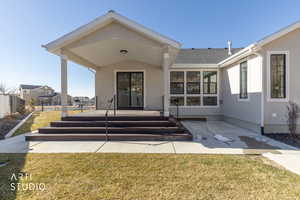 Rear view of house featuring a patio area, stucco siding, and roof with shingles