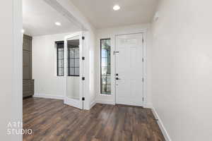 Foyer with dark wood finished floors and recessed lighting