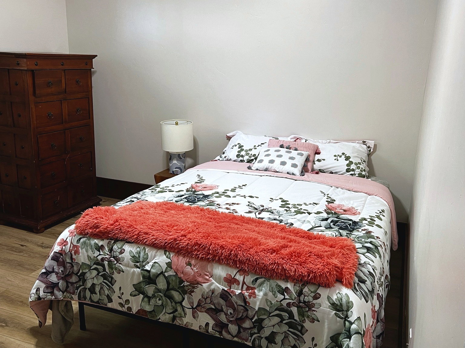 Bedroom featuring wood-finish flooring, light-toned walls, and dark baseboards