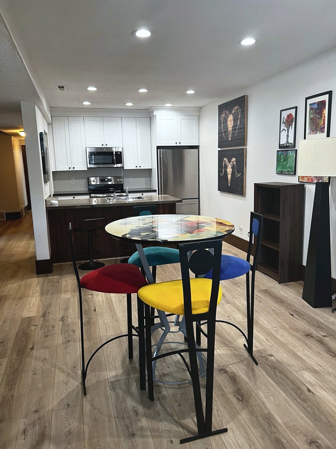 Contemporary kitchen featuring stainless steel appliances, white cabinetry, dark countertops, and recessed lighting