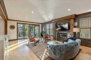 Living area featuring a fireplace.  View back to large windows leading to covered deck.
