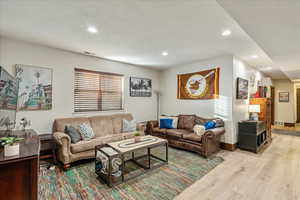 Living room featuring hardwood / wood-style flooring & recessed lighting.