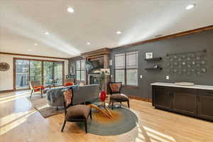 Living area featuring crown molding, light wood-style flooring, plenty of natural light, recessed lighting, built-in credenza
