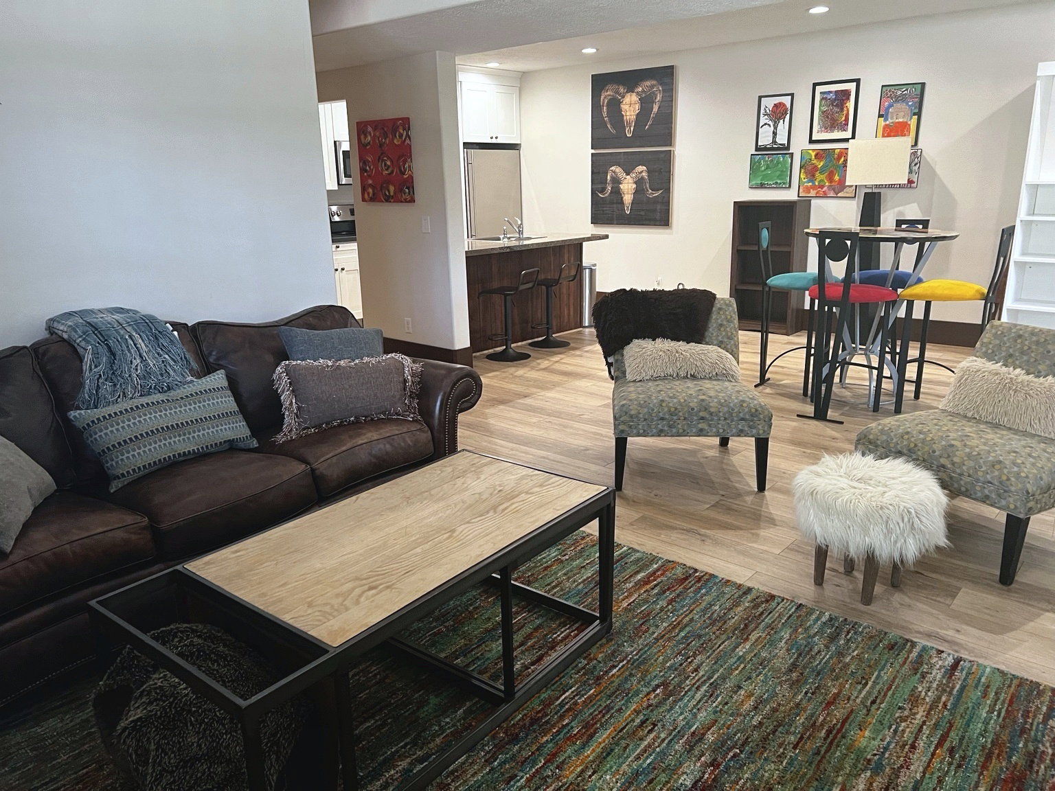 Open-concept living area featuring wood-finish flooring, a built-in bar, and recessed lighting
