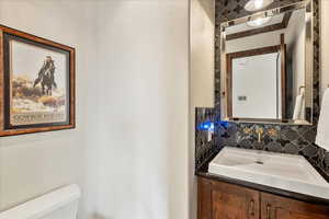 Half bathroom featuring vanity and backsplash