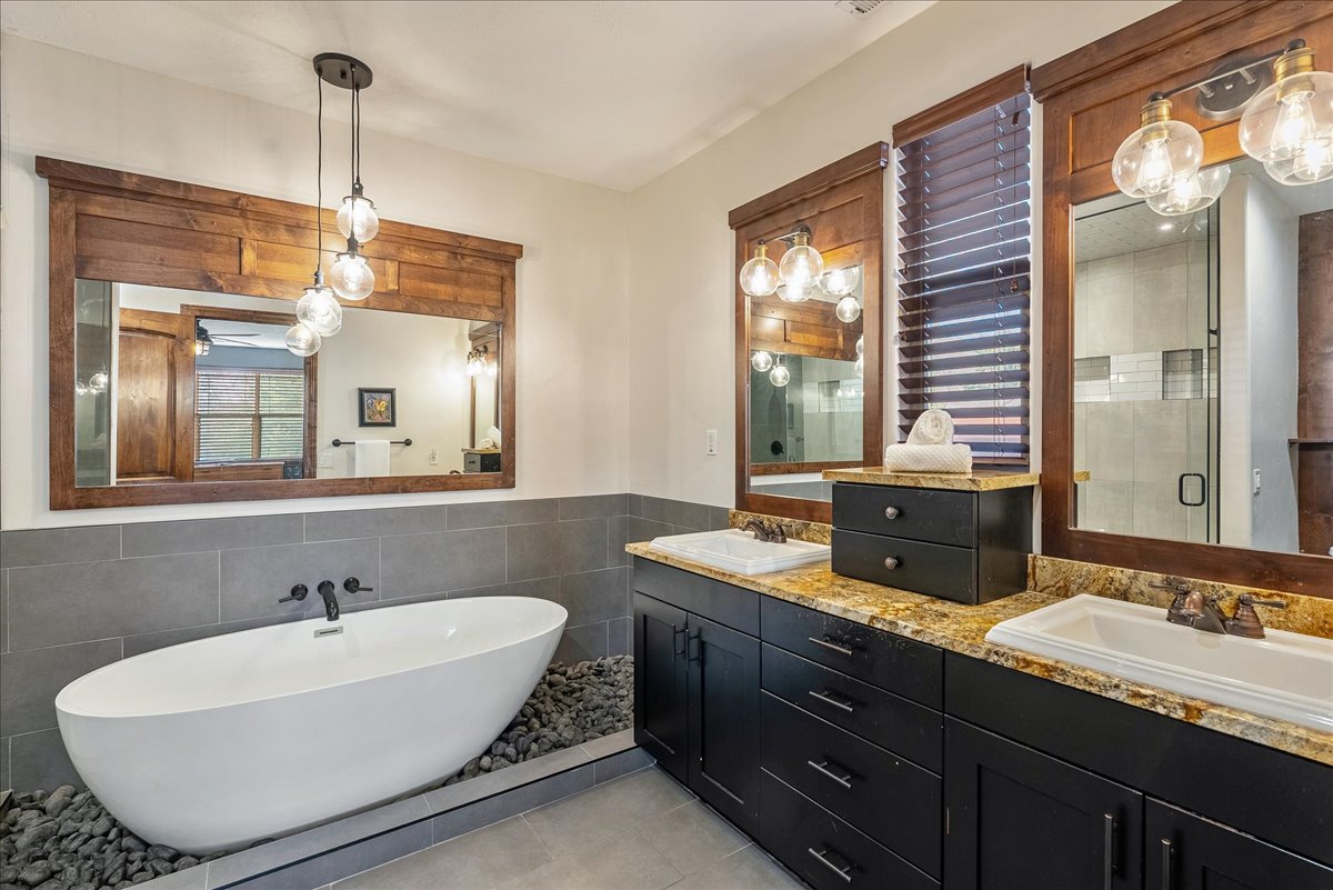 Grand primary bathroom featuring a spacious double vanity, a freestanding luxury soaking tub, and an expansive walk-in shower designed for a spa-like experience.
