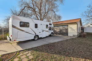 View of property exterior with an outdoor structure and driveway