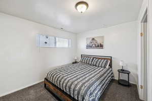Bedroom featuring carpet flooring and baseboards