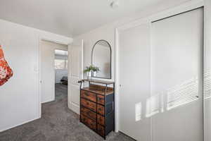 Bedroom featuring dark carpet and a closet