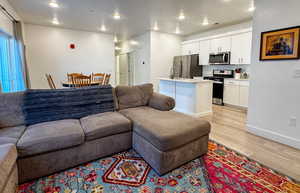 Living room with light wood-style flooring, recessed lighting, and a textured ceiling