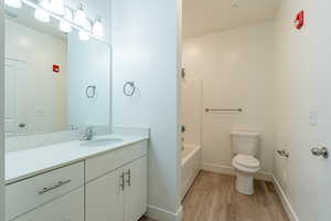 Bathroom featuring vanity, bathtub / shower combination, and light wood-type flooring
