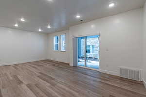 Unfurnished room with light wood-style flooring, a textured ceiling, and recessed lighting