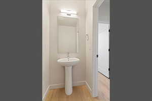 Half bath featuring light wood-type flooring and baseboards