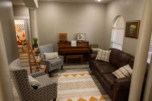 Living area featuring ornate columns and light wood-style floors