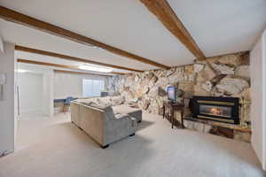 Carpeted living room with a fireplace and beam ceiling