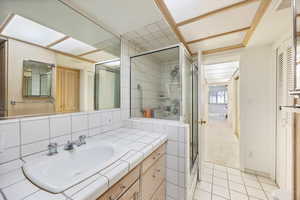 Full bathroom with vanity, a shower stall, a closet, and light tile patterned floors
