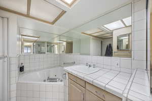 Full bath featuring vanity and a jetted tub