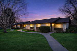 Single story home featuring brick siding and a front yard