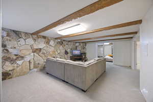 Living room with light carpet and beamed ceiling
