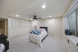 Bedroom featuring two closets, light carpet, ceiling fan, and recessed lighting