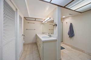 Full bathroom with a closet, double vanity, a stall shower, and light tile patterned flooring