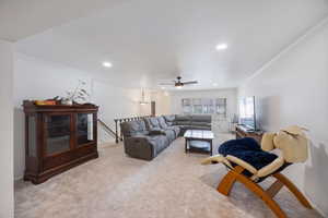 Living room featuring ornamental molding, light colored carpet, and recessed lighting