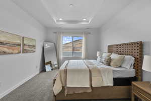 Bedroom with carpet, a tray ceiling, and a mountain view