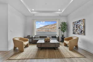 Living area with wood finished floors, a raised ceiling, and a mountain view