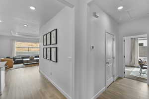 Hall with plenty of natural light, recessed lighting, and light wood-style flooring